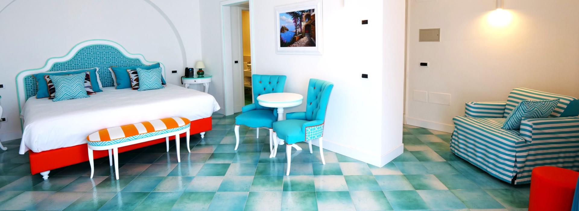 Bright room with turquoise furnishings and orange accents.