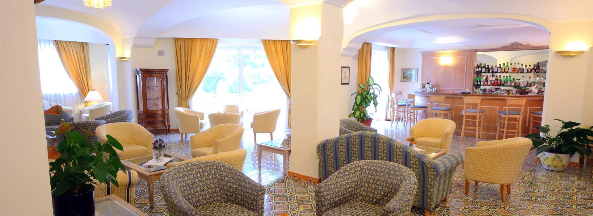 Elegante salotto d'albergo con arredi raffinati e un bar ben fornito.