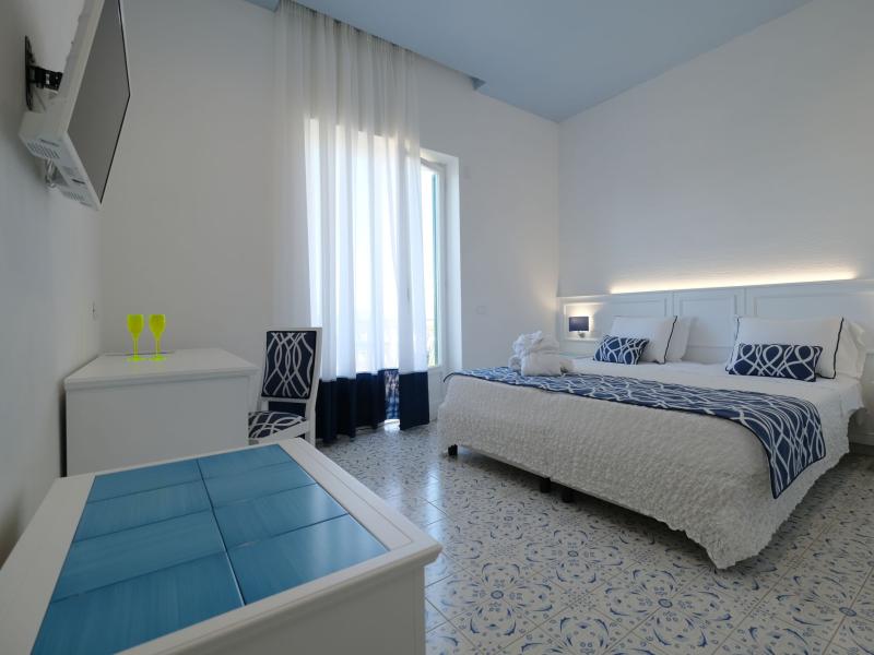 Modern room with double bed, blue and white decor.