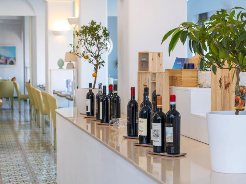 Elegant interior with wine bottles and decorative plants on a counter.
