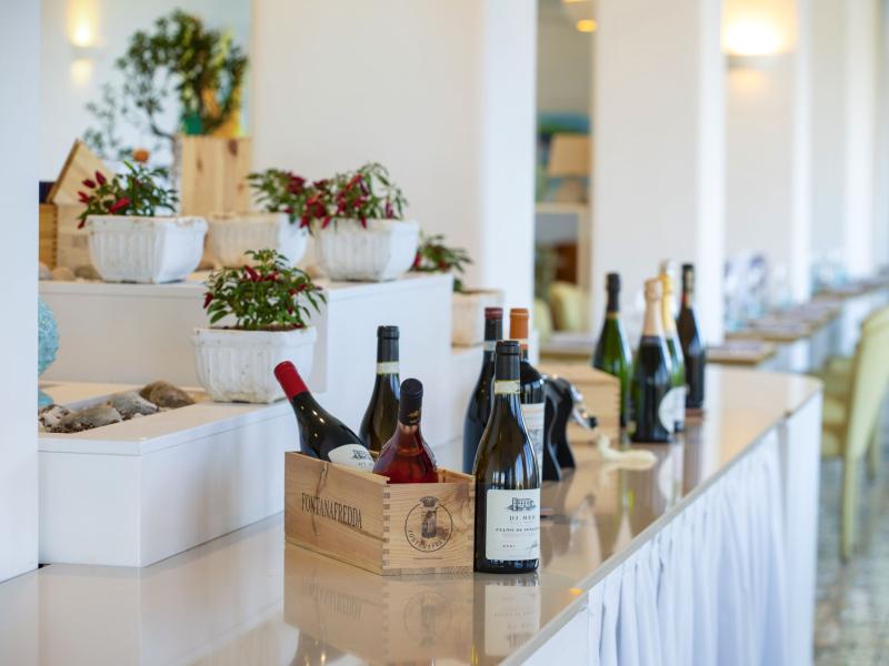 Wine bottles on an elegant table with decorative plants.
