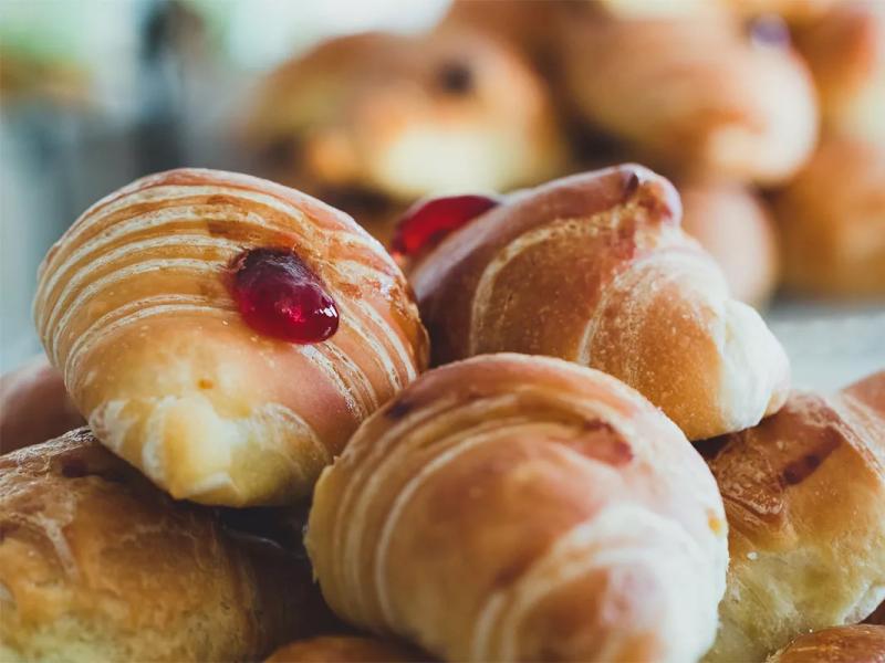 Cornetti dolci con marmellata di fragole in cima, perfetti per la colazione.