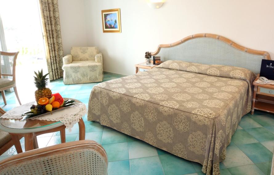Bright room with a double bed and fresh fruit.