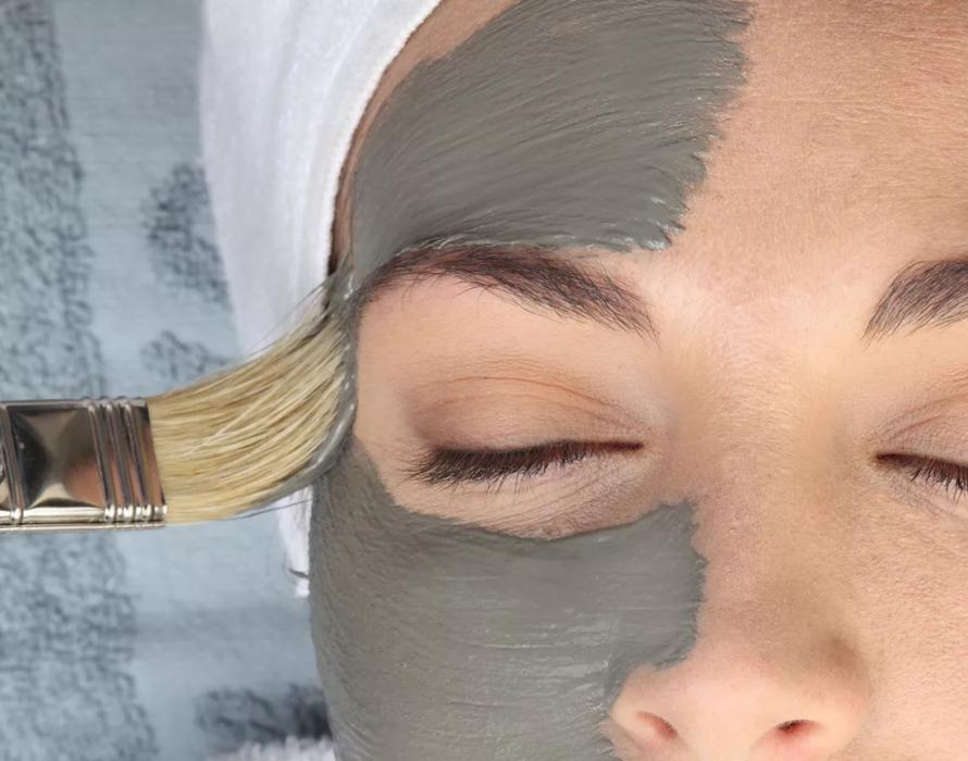 Maschera facciale applicata con pennello su viso rilassato con occhi chiusi.